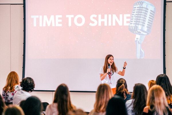 female student stood on stage talking through her time to shine presentation