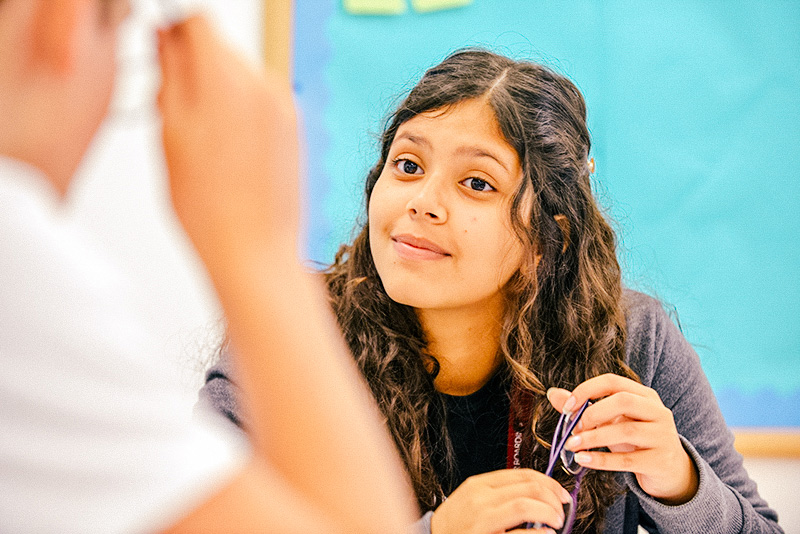 Student smiling and concentrating in class