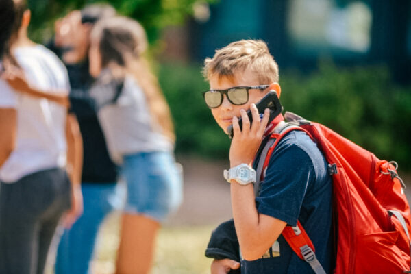 summer school student outside on his phone